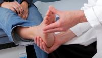 Physical examination of a patient's foot and ankle.